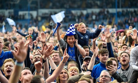 Portsmouth fans celebrate on the pitch after winning the League Two title on the final day of the season.
