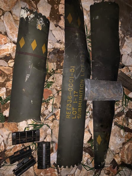 Remnants of a black missile, painted with yellow diamond markings, with yellow lettering that reads: submunition Lot 1-17