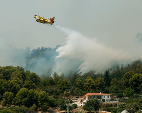 A firefighting plane makes a drop during a wildfire in Betxi, Spain.