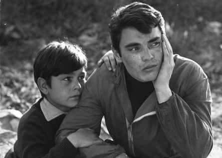 A man sitting crying with a boy holding his arm