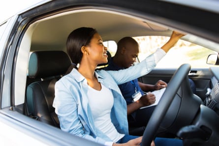 A woman driving a car as a male passenger sits beside her