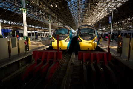 Two trains seen head on at the platforms under the arches of the station.