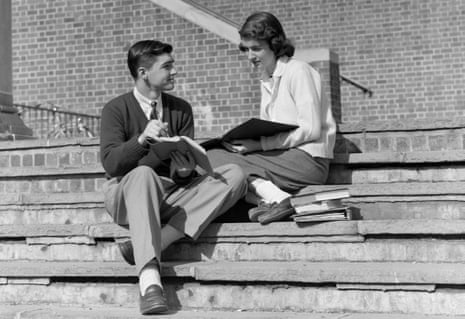 1950s TEENAGE MAN WOMAN SITTING ON STEPS OUTSIDE OF SCHOOL COLLEGE BOOKS NOTES ON LAP STUDYING TALKING (Photo by H. Armstrong Roberts/ClassicStock/Getty Images)