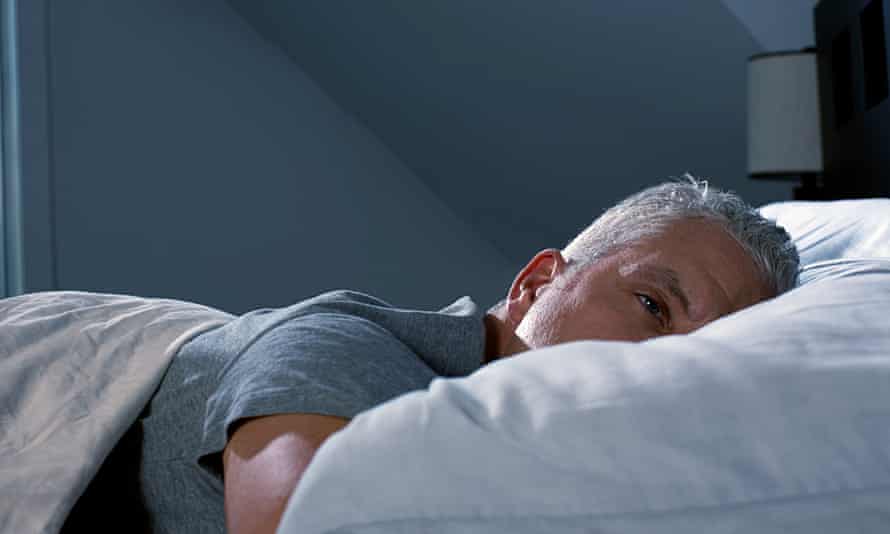 Man lying awake in bed