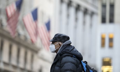 A man wearing a face mask walks on a street in Manhattan of New York.