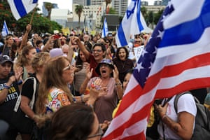 Crowd of people cheering amid Israeli and US flags