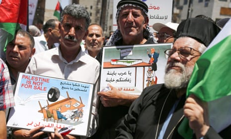 Palestinian demonstrators carry caricatures, during a protest against the US-led Peace to Prosperity conference that opens tomorrow in Bahrain, in the Israeli-occupied West Bank city of Ramallah on Monday.