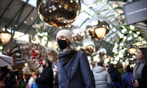 A person wearing a protective face mask walks through Covent Garden amid the coronavirus outbreak in London.