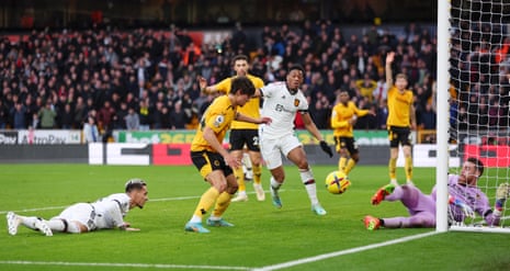 Wolves keeper Jose Sa looks on after saving a header from Antony of Manchester United as Hugo Bueno attempts to clear the ball.