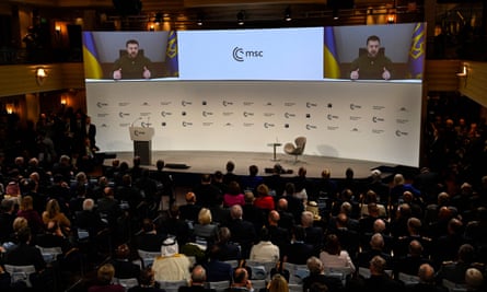 Participants watch Zelenskiy on a screen during the Munich Security Conference