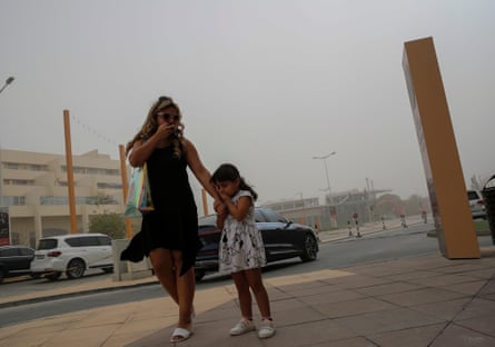 Woman and girl on street during a heavy sandstorm in Dubai.