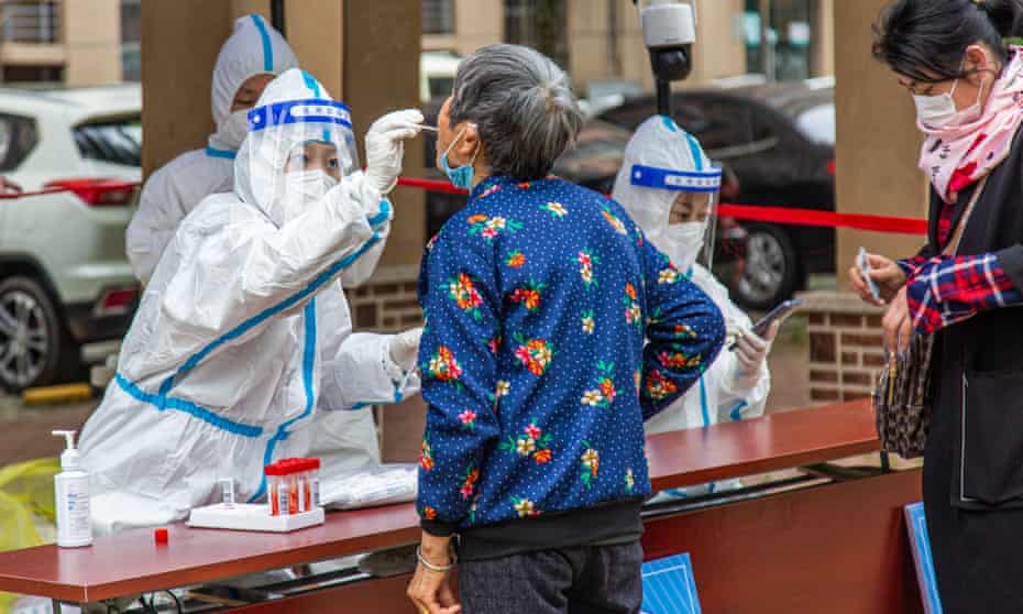 A medical worker collects a Covid swab sample from a Beijing resident