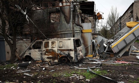 A destroyed vehicle near a residential building damaged by shelling in Bakhmut.