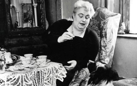 Margery Allingham, feeding one of her dogs at home.