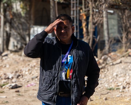 A man shields his face with his hand from the sun.