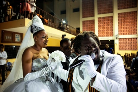 Musician Duckyns St Eloi, who is known as ‘Zikiki’ sings to his bride Mirla-Samuelle Pierre as she enters the church with her father Pierre Obas on their wedding day at Église de l’Universite Adventiste d’Haiti, a church in Diquini, Carrefour
