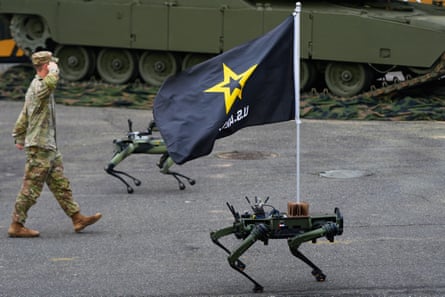 Robot dogs walk past the reviewing stand.