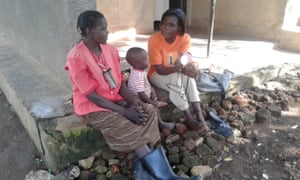 Harriet Nabukwasi (right) explains to her neighbour how a solar lamp works