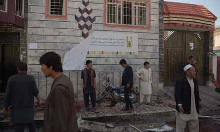 Afghan residents inspect the site of a suicide bombing outside a voter registration centre in Kabul on Sunday
