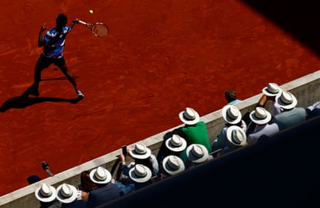 Spectators take precautions against the sun as the watch Elias Ymer fire off a forehand to Casper Ruud.