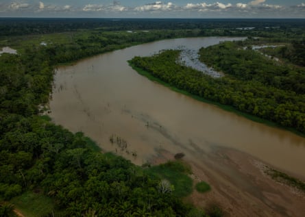 Aerial view of muddy brown river amid tropical rainforest