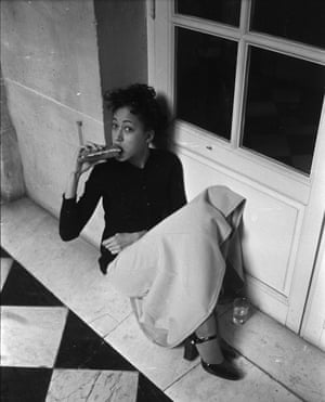 Pat Cleveland eating a sandwich at the Battle of Versailles in 1973
