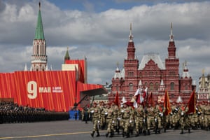 Soldiers march across Red Square in Moscow, with buildings behind them