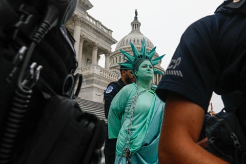 a person being handcuffed while dressed as statue of liberty