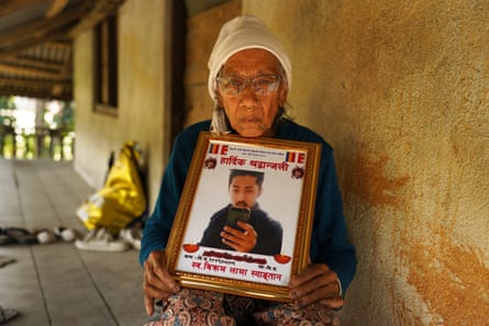 Seti Maya Lama holds a framed image of her son