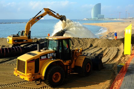 Digger and bulldozer replenishing the disappearing sand on Barcelona’s beaches.