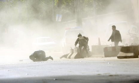 Security forces run from the scene of a suicide attack in Kabul on Monday.