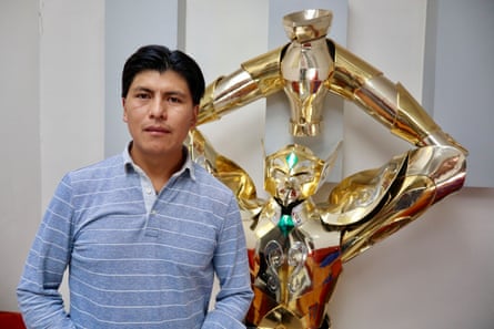 a man stands beside a futuristic statue