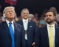 a man in a suit and tie looks at another man in a suit and tie with a bandage on his ear