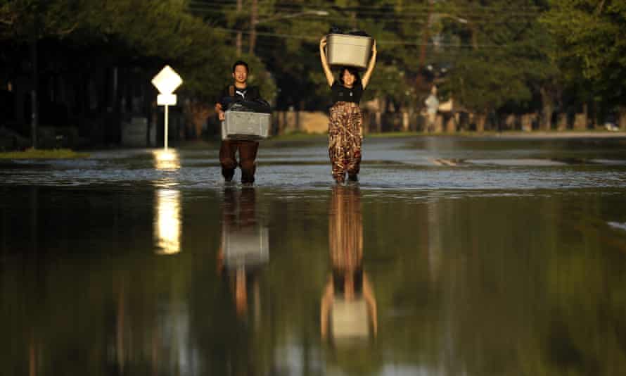 In this September 2017 photo, Mariko Shimmi helps carry items out of Ken Tani’s home in a Houston neighborhood still flooded from Hurricane Harvey.