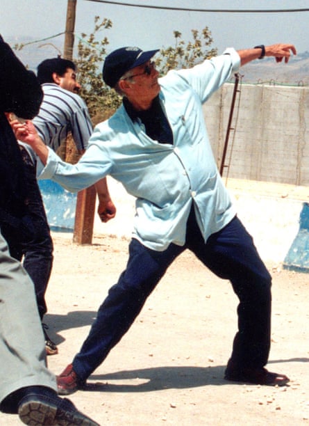 man in baseball cap throws stone