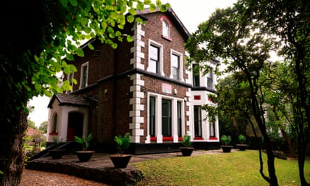 A wide shot of the building, framed by trees