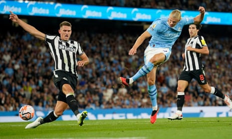 Newcastle's Sven Botman, left, tries to block a shot from Manchester City's Erling Haaland.