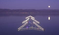 Moon  over Christmas lights on Lake Trasimeno Lake in Castiglione del Lago, Italy.