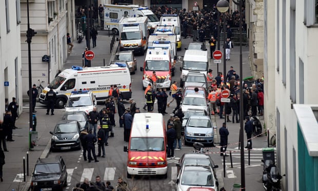 Firefighters, police officers and forensic teams outside the offices of Charlie Hebdo in Paris on 7 January 2015.
