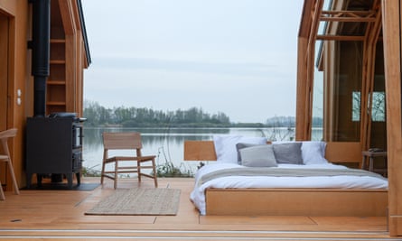 The cabin with its glass doors completely open, so the bedroom is in the open air.
