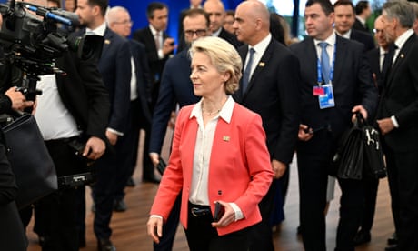 Ursula von der Leyen walks past cameras and men in suits