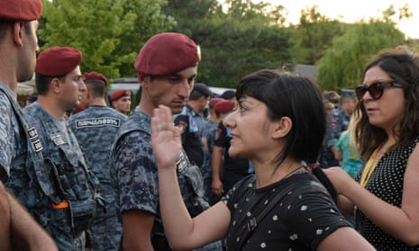 An Armenian opposition member stand in front of military forces during a protest in central Yerevan.