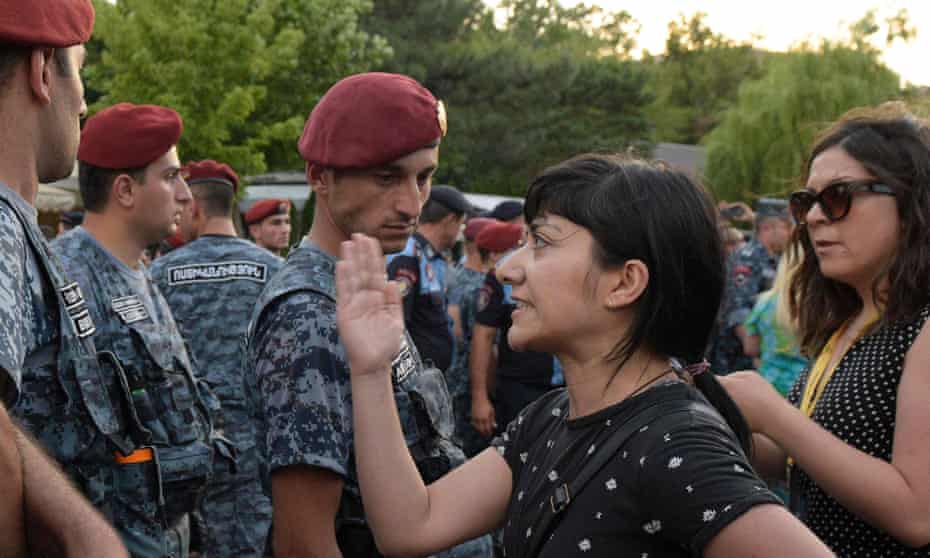 An Armenian opposition member stand in front of military forces during a protest in central Yerevan.