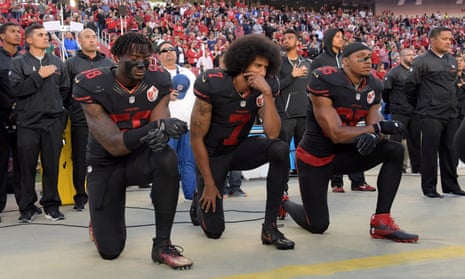 Colin Kaepernick, center, protests before a game against the Arizona Cardinals last October.