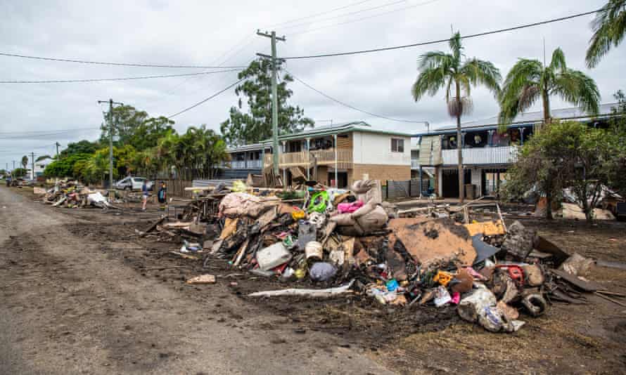 Rubbish and flood-damaged belongs piled up on the side of a muddy street in Coraki, New South Wales