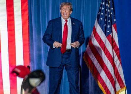 An open-mouthed Donald Trump walks out on stage between US flags