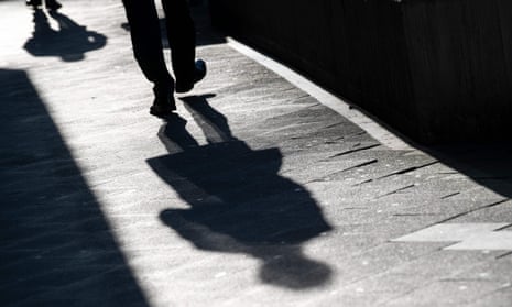 A man casts a long shadow on the pavement