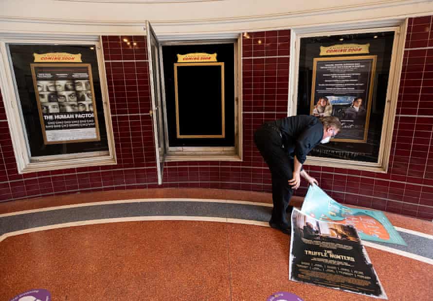 Dave Parker, general manager, replaces film posters at the entrance to the Tower Theater on Friday in Sacramento.