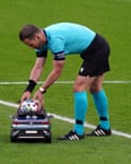 Referee Danny Makkelie retrieves the match ball from a remote control car