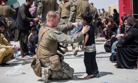 A US marine provides fresh water to a child during an evacuation at the airport in Kabul on Friday.